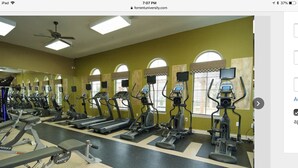 A gym with treadmills, elliptical machines, and weight benches. - Apt for Sublease near TEEX (College Station)