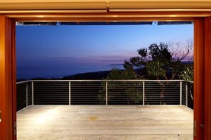 Un balcon donnant sur la mer au crépuscule.