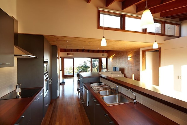A modern kitchen with a central island, built-in appliances, and pendant lighting.