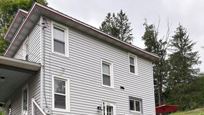 Ein zweistöckiges Haus mit einer Steintreppe, die zur Haustür führt.