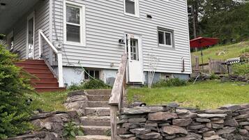 A two-story house with a stone staircase leading to the front door.