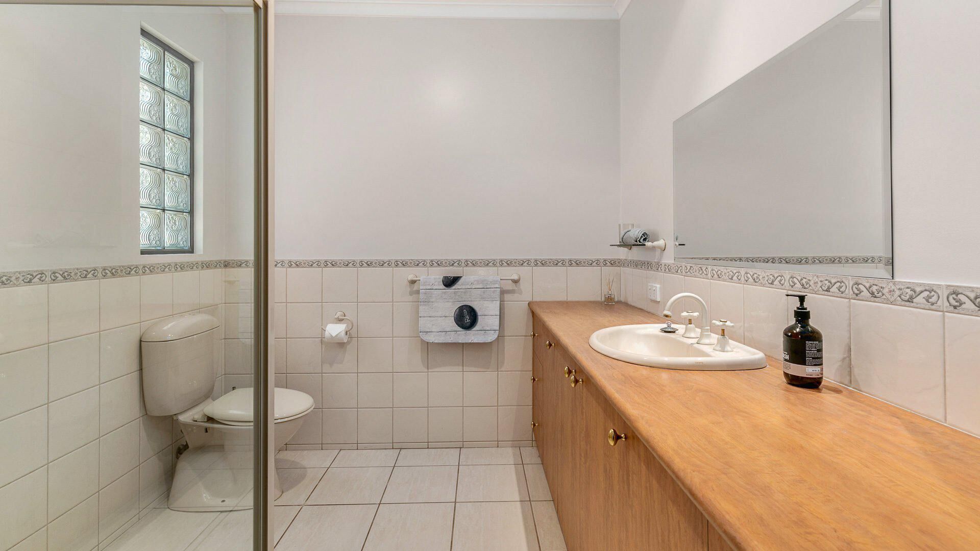 A bathroom with a toilet, a sink, and a mirror.