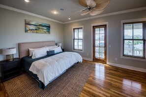 Bedroom with Large Bed, Nightstands, Lamps, Ceiling Fan, and French Door.