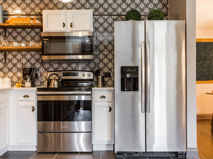A modern kitchen with stainless steel appliances, including a refrigerator, oven, and microwave.