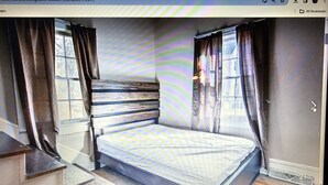 Une chambre à coucher avec un lit, des rideaux et une fenêtre.