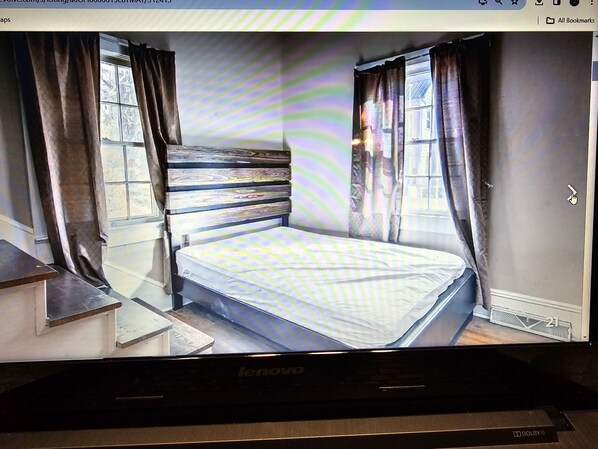 Une chambre à coucher avec un lit, des rideaux et une fenêtre.