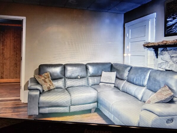 A sectional sofa with a patterned throw pillow and a matching pillow on the armrest. - Spacious riding retreat 4 BR Outlaw House/ ATV Riding 10beds-Large Parking (Northfork)