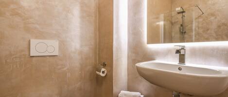 Un baño con inodoro, lavamanos y espejo.