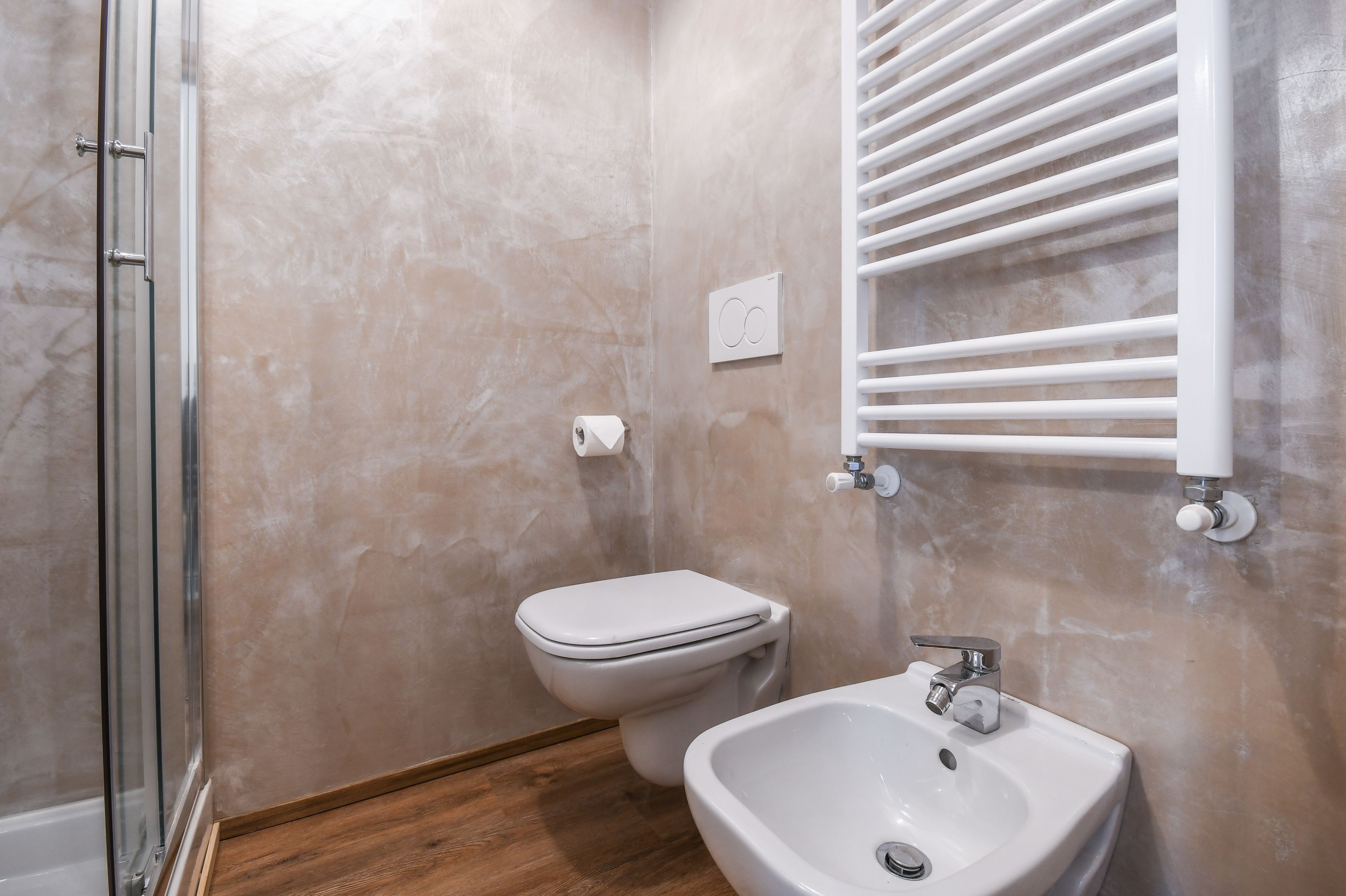 Une salle de bain équipée de toilettes, d’un bidet et d’un lavabo.