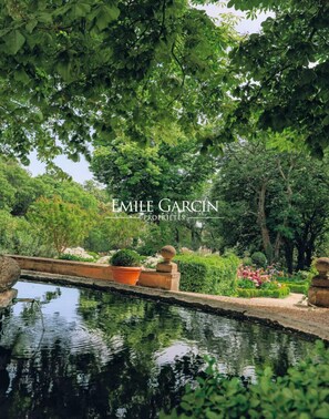 A serene garden with a reflective pool, lush greenery, and a stone bridge. - Bastide for rent 10 min from Aix-en-Provence amidst vineyards (Aix-en-Provence)