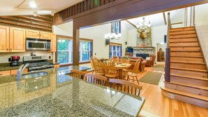 A spacious kitchen with granite countertops, wooden cabinets, and a built-in microwave.