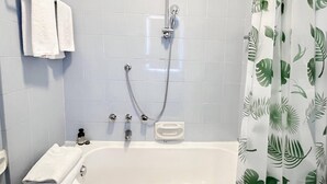 A bathroom with a bathtub, a shower, and a curtain with a leaf pattern. - Colourful apartment  St. Peter's View (ROMA)