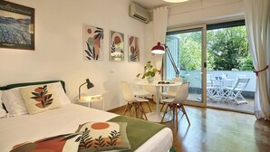 A hotel room with a bed, a desk, a chair, a table, and a balcony with outdoor furniture. - Colourful apartment  St. Peter's View (ROMA)
