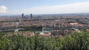 A panoramic view of a cityscape with a river, historic buildings, and modern skyscrapers.