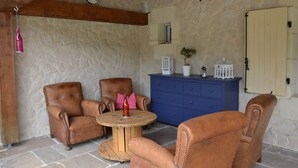 Un interior rústico con paredes de piedra, muebles de madera y un reloj.