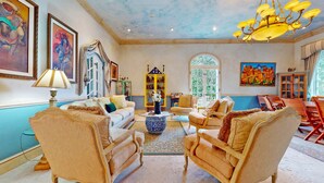 A spacious living room with a high ceiling, comfortable seating, and artwork on the walls. - Casa Tranquila Miami, A Luxury Ranch-Style Retreat (Miami)