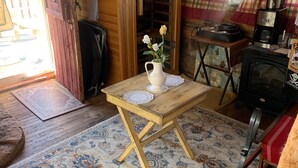 A cozy room with a wooden table, a rug, a coffee machine, and a stove. - Colorado Cabin with Hot tub, sauna, cold plunge! (Colorado)