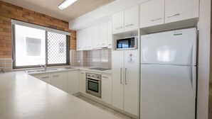 A modern kitchen with white cabinets, a stainless steel oven, a built-in microwave, and a refrigerator. - San Clemente No. 2. 24 Orvieto Terrace (Kings Beach)