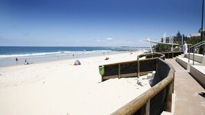 Ein Strand mit einer Holzstege zu einer Aussichtsplattform.