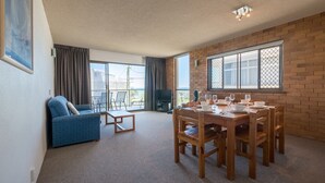 A spacious living area with a balcony, a dining table set with plates and glasses, a blue sofa, and a television. - San Clemente No. 2. 24 Orvieto Terrace (Kings Beach)