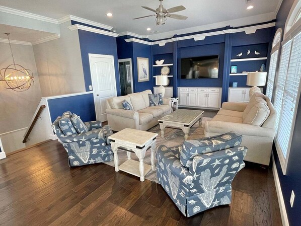 A living room with a sofa set, coffee table, and a television.