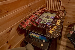 Una mesa de madera con una consola de videojuegos y un joystick.