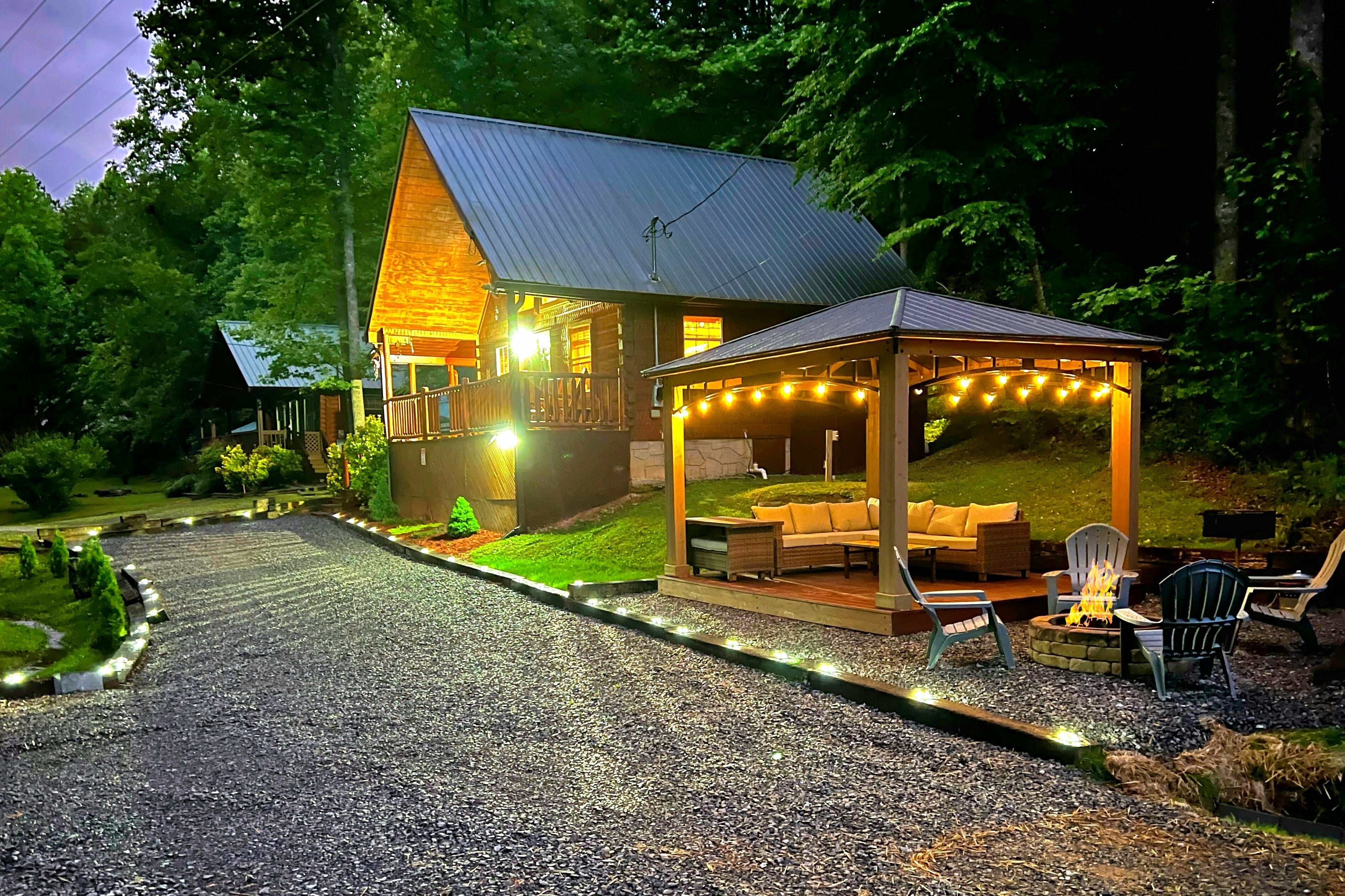 A lodge with a covered porch, outdoor seating, and a gravel driveway.