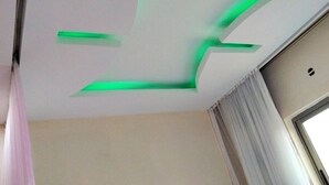 A room with a ceiling featuring a green light fixture and a window with curtains. - Sunset Paradise Baringo 12 (Mombasa)