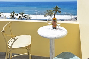 A balcony with a chair, a small table, and a bottle of wine. - Apartamento Sabino en Puerto Naos (Puerto Naos)