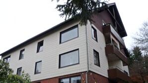 A multi-story building with a flat roof, large windows, and a brick base.