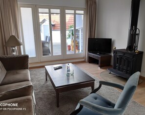 Relax in this stylish living room with a comfortable sofa, armchair, and flat-screen TV.