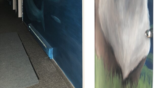 En hall med en väggmålning som föreställer en älg och en val.