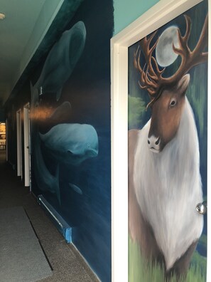 A hallway with a mural of a moose and a whale.