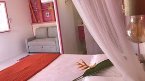 Ein Schlafzimmer mit Bett, Nachttisch, Fenster und einer rosafarbenen Wand.