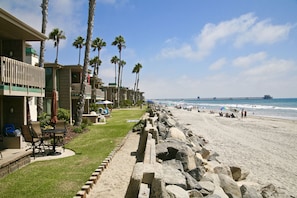 Ein Strandhotel mit Poolbereich, Palmen und Blick auf das Meer und den Pier.