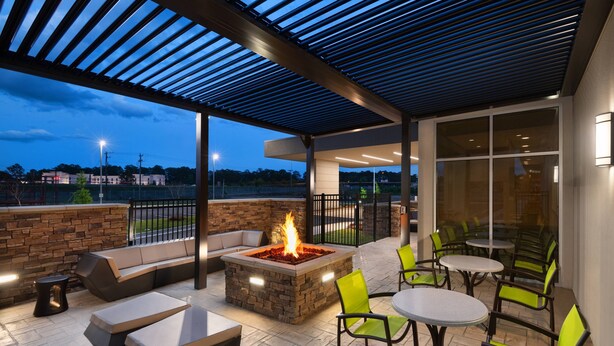 An outdoor patio area with a fire pit, seating, and tables. - SpringHill Suites by Marriott Tifton (Tifton)