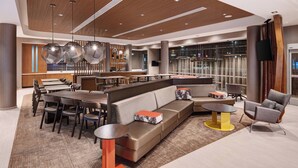 A modern lobby with a seating area, a bar, and a kitchen in the background. - SpringHill Suites by Marriott Tifton (Tifton)