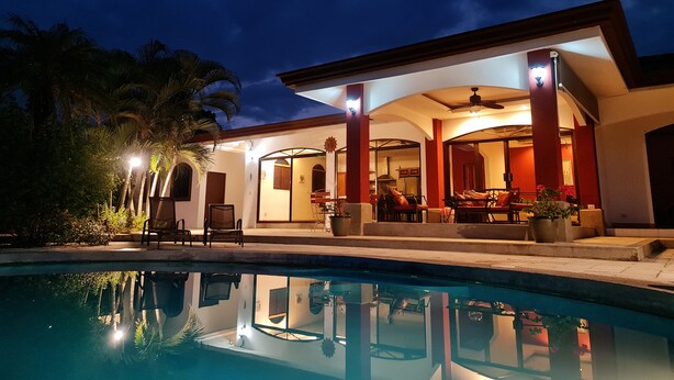 A modern house with a pool, outdoor seating, and a covered patio area. - Ocean View Single Story House with Private Infinity Pool.  10 min walk to Beach (Playas del Coco)