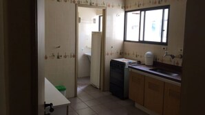 A kitchen with a window, a sink, cabinets, and a dishwasher. - Cozy, well-furnished apartment on a quiet street near the beach. (Guaruja)