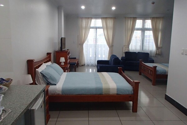 Habitación doble familiar, 2 camas Queen size, vista a la ciudad | Cortinas blackout, tabla de planchar con plancha, wifi y ropa de cama 