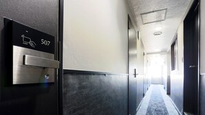 A modern hotel hallway with a digital card reader labeled '507' and a carpeted floor.