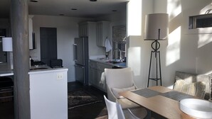 A modern kitchen with a refrigerator, stove, and sink. There is a dining area with a table and chairs. - Renovated  Running Y Ranch Resort Home (Klamath Falls)