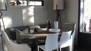 A modern living room with a wooden coffee table, white chairs, a grey sofa, a cowhide rug, and a large window. - Renovated  Running Y Ranch Resort Home (Klamath Falls)