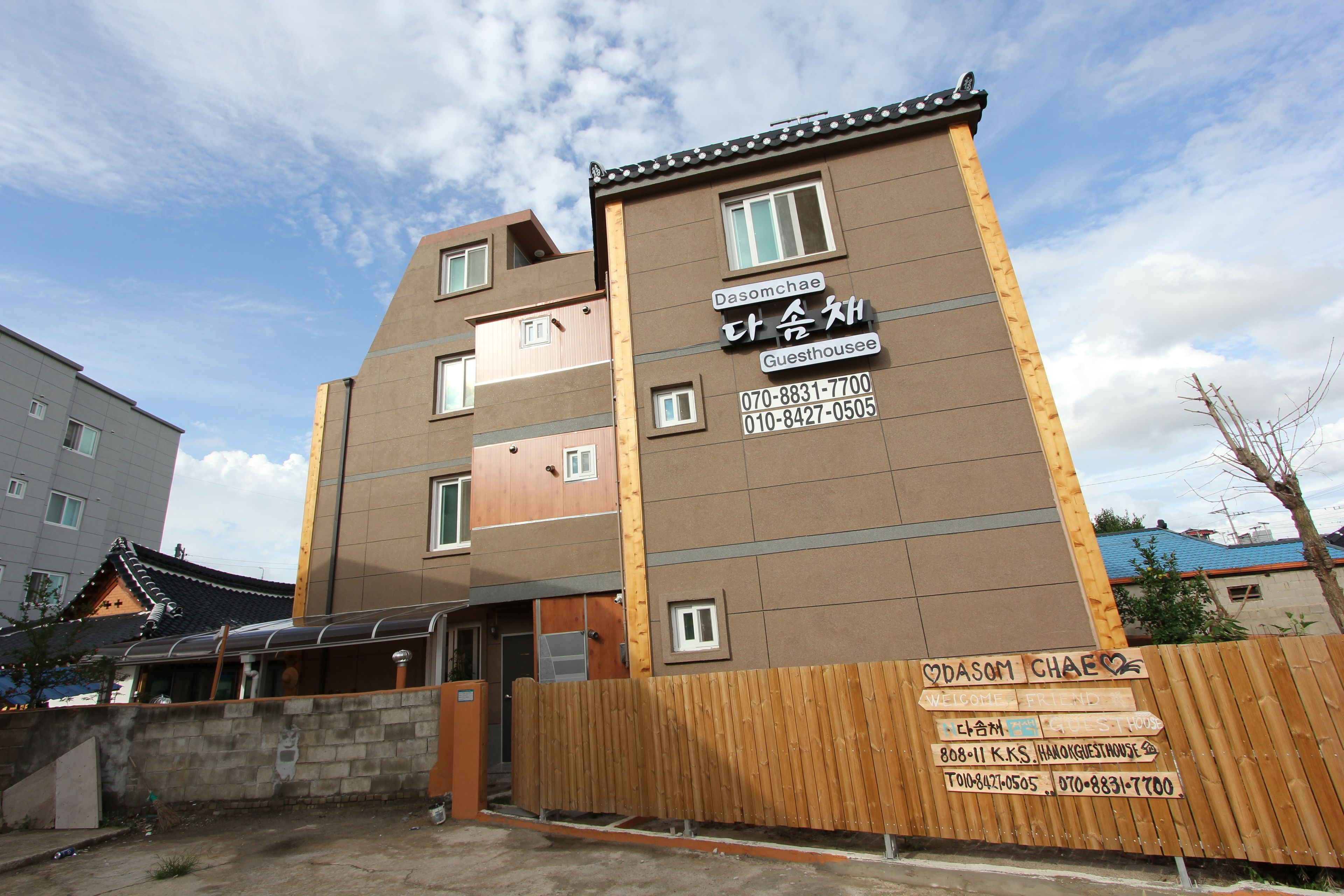 A guesthouse with a traditional architectural style, featuring a wooden facade and multiple windows.