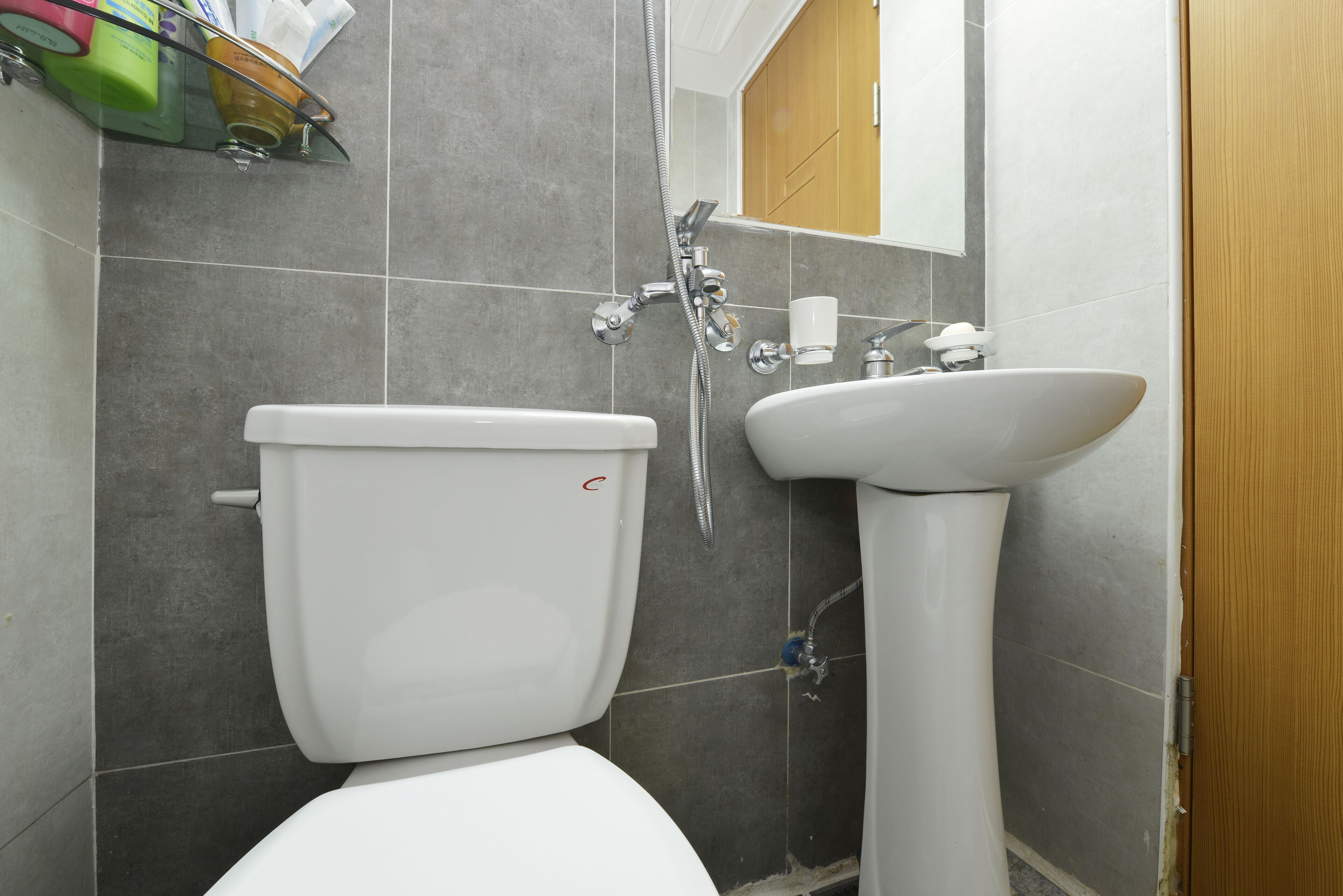 A bathroom with a toilet, sink, and shower.
