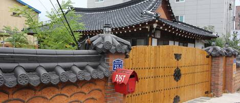 A traditional Korean gate with a red mailbox labeled "POST" and a blue sign with the number "271".