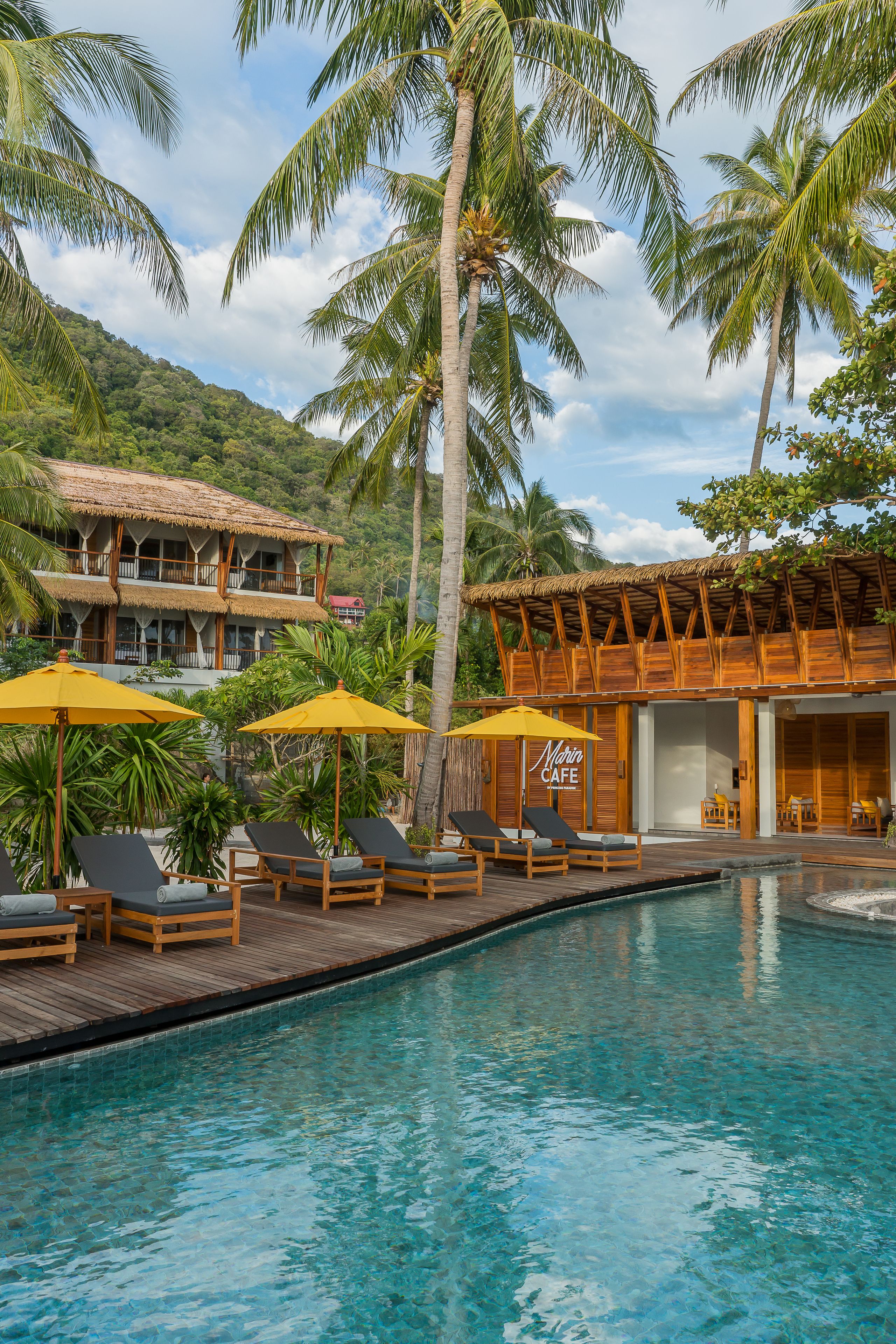 Ein Resort mit Pool, Liegestühlen und Sonnenschirmen.