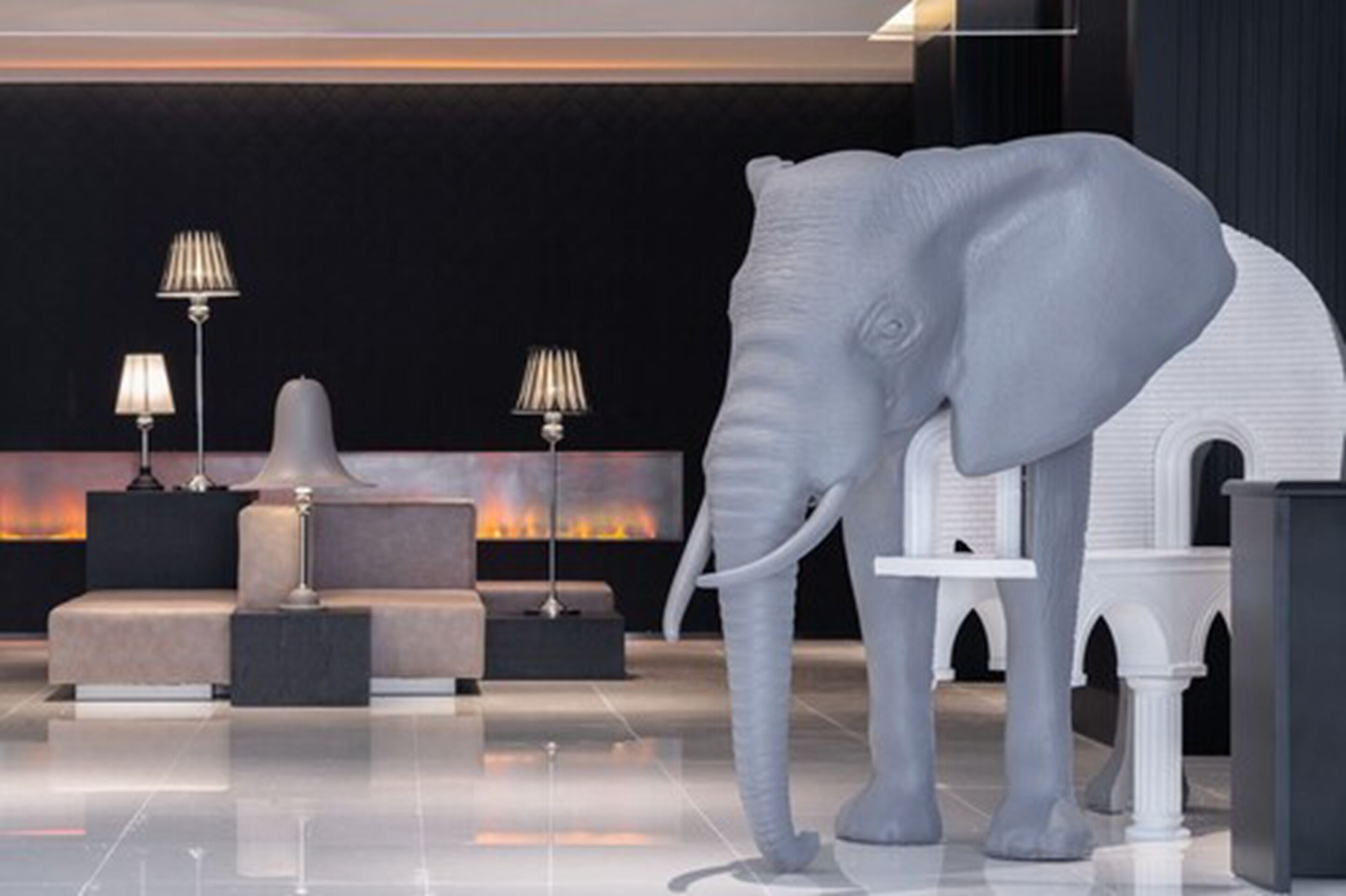 A modern lobby with a large elephant sculpture, a fireplace, and contemporary furniture.