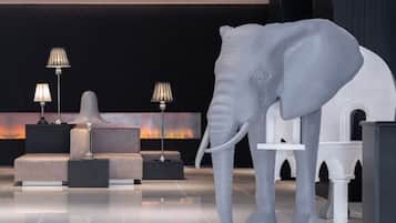 A modern lobby with a large elephant sculpture, a fireplace, and contemporary furniture.