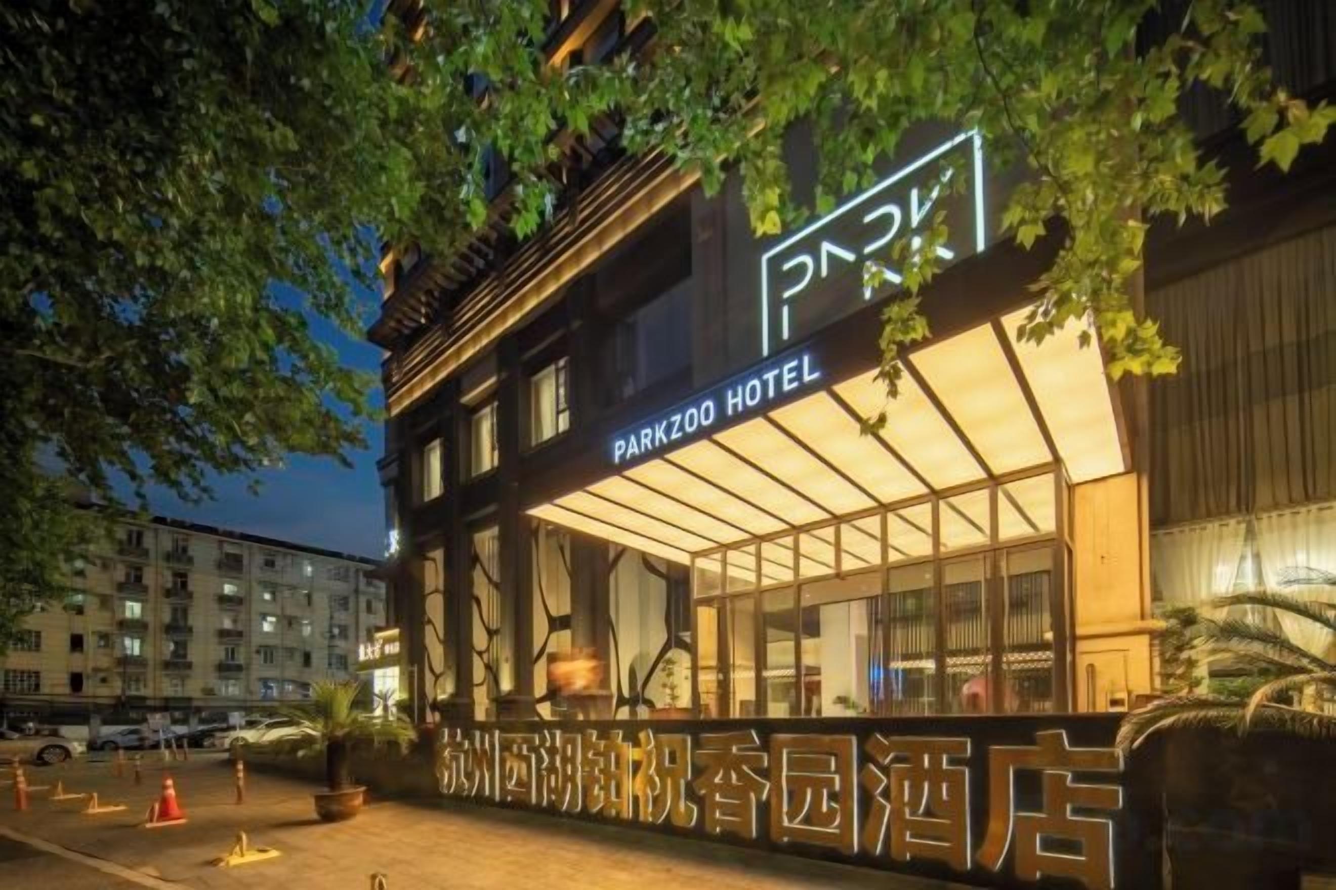 A hotel with a modern facade, large windows, and a prominent sign.